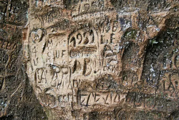 SIGULDA, LATVIA - 17 DE MARZO DE 2012: Antiguas inscripciones en la Cueva de Gautmanis, ubicada sobre el río Gauja en el Parque Nacional de Sigulda, Letonia —  Fotos de Stock