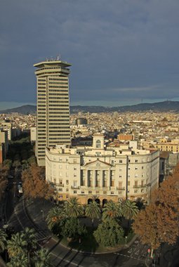 BARCELONA, SPAIN - DECEMBER 12, 2011: Columbus tower the highest (110 meters) construction in the center of Barcelona and Sector Naval de Catalunya - government building. View from Columbus monument