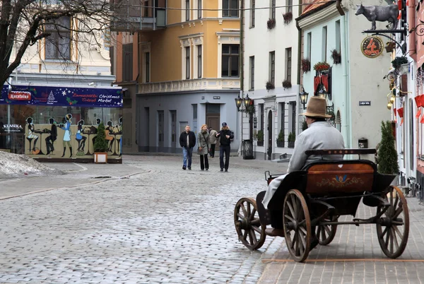 RIGA, LETTONIE - 18 MARS 2012 : Rue Meistaru à Old Riga, Lettonie. Vieux chariot est utilisé comme une publicité pour le restaurant — Photo