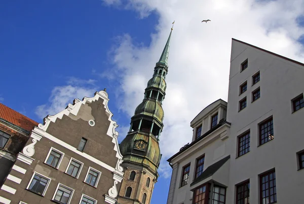 RIGA, LATVIA - 19 de março de 2012: Igreja de São Pedro em Riga com casas vizinhas — Fotografia de Stock