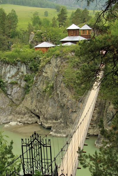 ALTAI, RUSSIA - 11 GIUGNO 2012: Ponte sospeso per il monastero sull'isola di Patmos, Altai, Russia — Foto Stock