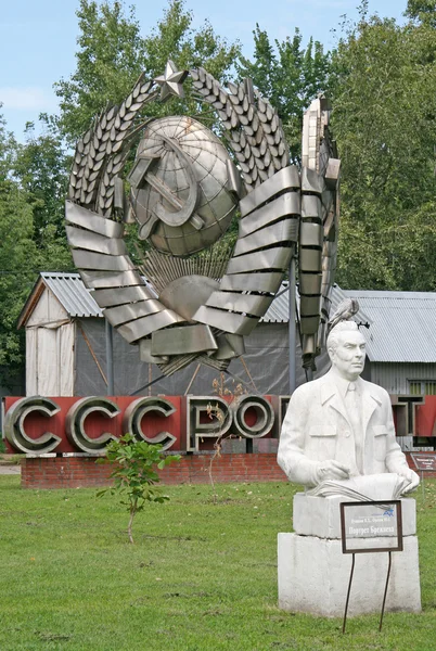 MOSCOW, RÚSSIA - 02 de agosto de 2008: Escultura antiga de Leonid Brezhnev e antigo símbolo soviético - o emblema (brasão de armas) no Muzeon Art Park (Fallen Monument Park) em Moscou — Fotografia de Stock