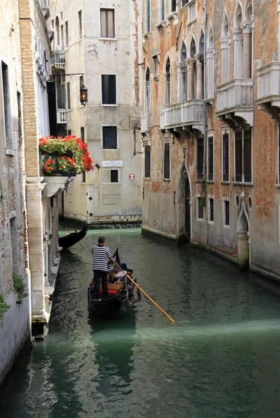 VENECIA, ITALIA - 02 DE SEPTIEMBRE DE 2012: Gondolier monta góndola en un canal estrecho, Venecia, Italia — Foto de Stock