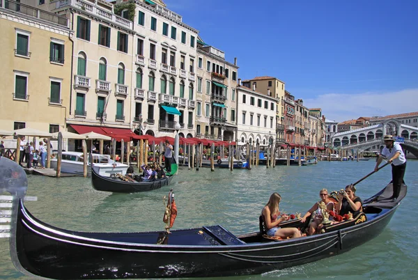 VENECIA, ITALIA - 02 DE SEPTIEMBRE DE 2012: Gondolier monta góndola en el Gran Canal cerca del Puente de Rialto en Venecia — Foto de Stock