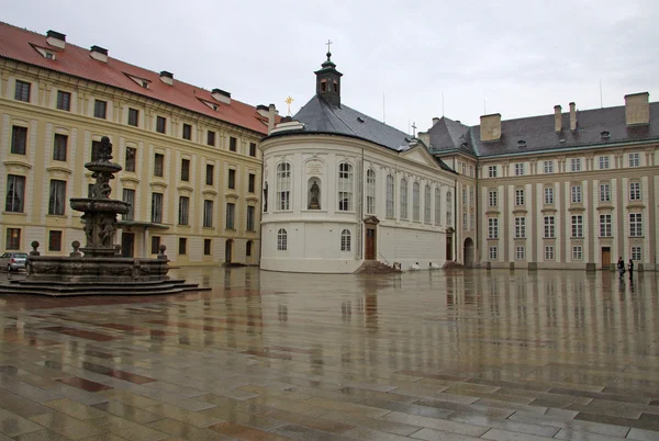 Prága, Cseh Köztársaság-április 29, 2013: a második udvar a prágai kastélyban szökőkúttal és a Szent Rood kápolnával, Prága, Cseh Köztársaság — Stock Fotó