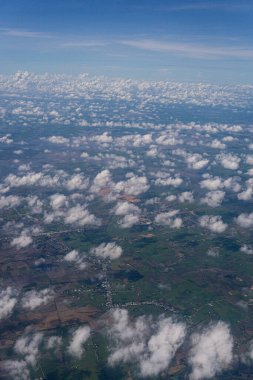 Gökyüzü bulutlarla dolu ve güneş onların arasından parlıyor. Bulutlar tüm gökyüzüne dağılmış, derinlik ve hareket hissi yaratıyor.