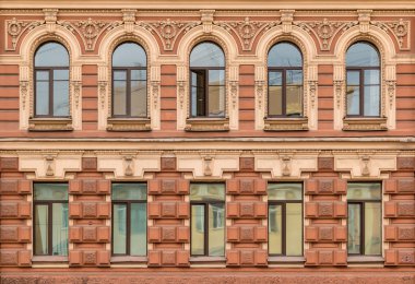 Apartman binası cephesinde arka arkaya pencereler