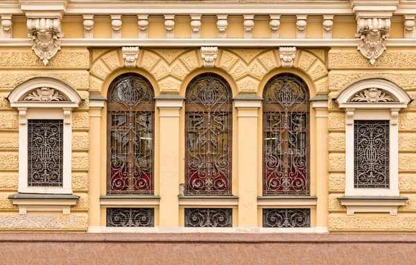 Windows z rzędu z kutego ruszt na elewacji budynku biurowego — Zdjęcie stockowe