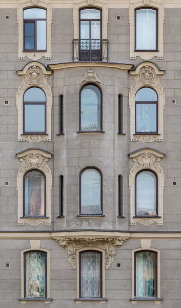 Fenêtres dans une rangée et baie vitrée sur la façade de l'immeuble — Photo