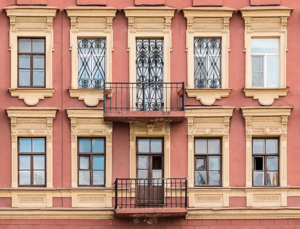 Ventanas en una fila y balcones en la fachada del edificio de apartamentos — Foto de Stock