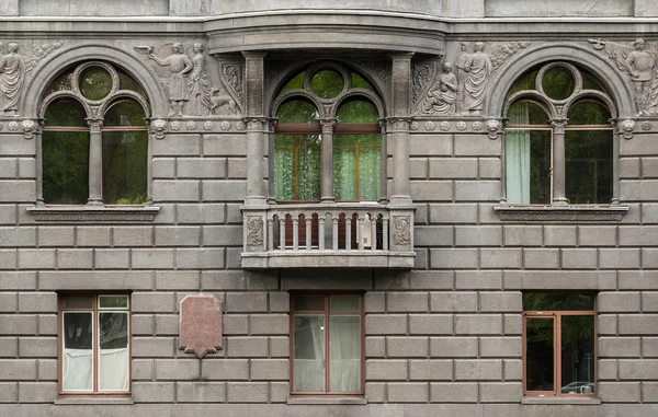 Ventanas en una fila y balcón en la fachada del edificio de apartamentos — Foto de Stock