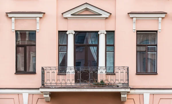 Janelas em uma fileira e varanda na fachada do prédio de apartamentos — Fotografia de Stock