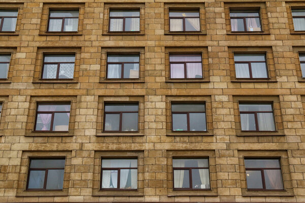 Many windows in row on facade of urban apartment building front view, St. Petersburg, Russia