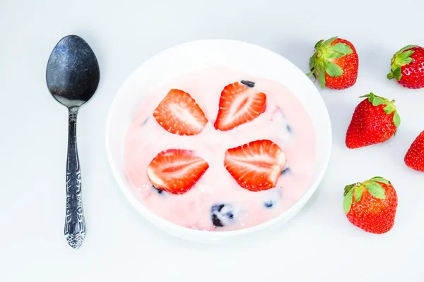 Yogur de fresa y uva negra en el bowl sobre la mesa blanca — Foto de Stock