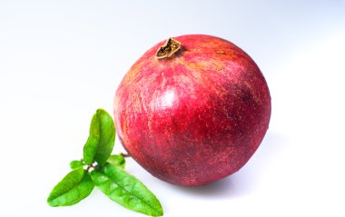 Nar taneleri ve beyaz zemin üzerine yeşil yaprakları