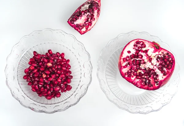 Pomegranate seeds and green leaves on the white background — Stock Photo, Image