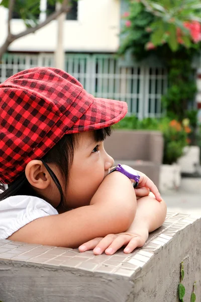 Asiatische kleine Mädchen sitzt seine Hand auf Kinn — Stockfoto