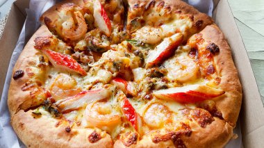 Pizza teslim kutusundaki lezzetli deniz ürünleri ile