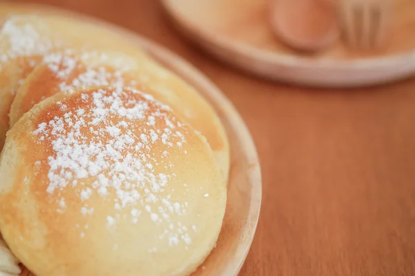 Pfannkuchen mit Puderzucker auf Holzteller — Stockfoto