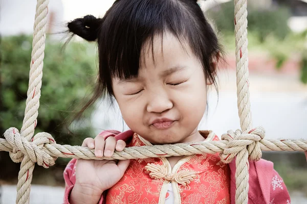 Το θλιβερό κοριτσάκι πίσω από ένα σχοινί ματιών. — Φωτογραφία Αρχείου