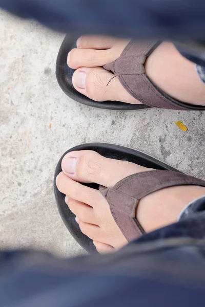 Feet of men wearing black sandals