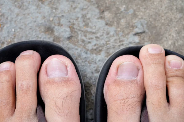 Feet of men wearing black sandals — Stock Photo, Image