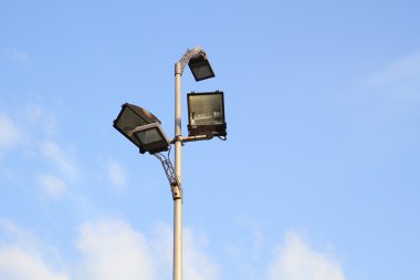 Elektrik direğine reflektör mavi gökyüzü arka plan üzerinde