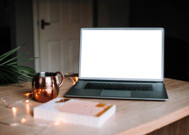 Work from home concept, cozy office with decoration and isolated laptop computer mockup with blank white display