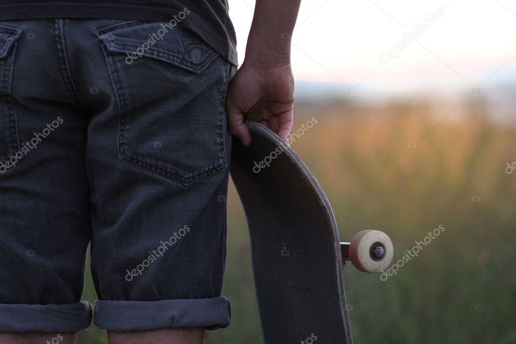 Close up image of a skateboarder at sunset