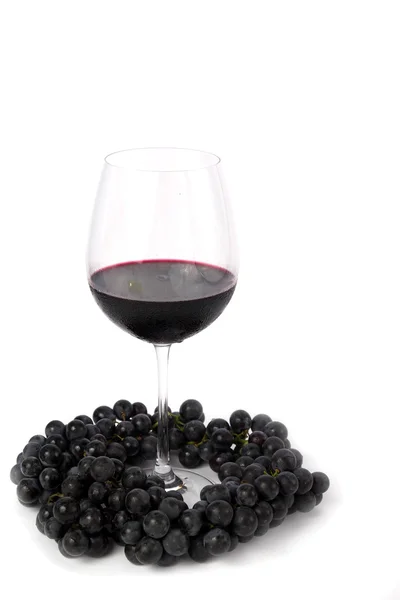 Bouquet de raisins noirs et verre de vin rouge Photo De Stock