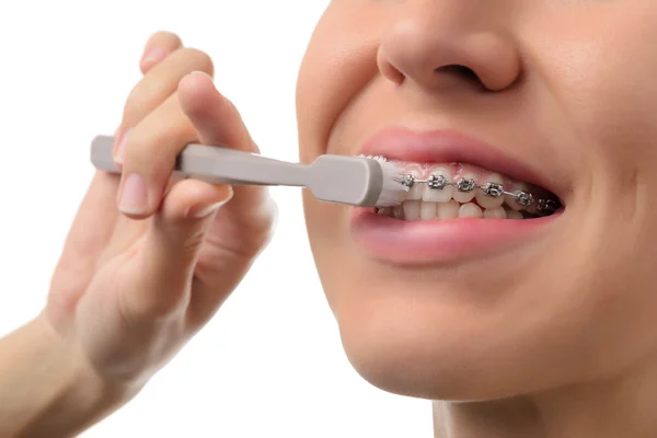 Жінка з зубними брекетами тримає зубну щітку — стокове фото