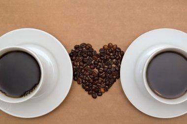 İki bardak kahve ve kahve çekirdekleri kalp şeklinde