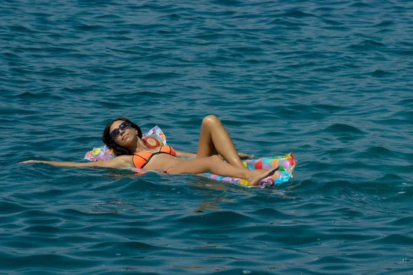 Žena na nafukovací matrace v moři — Stock fotografie