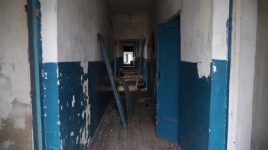 Terk edilmiş okul, boş koridor, kırık bir kapı, bakış açısı.