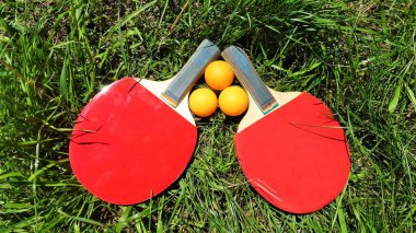 Yeşil çimlerde kırmızı tenis raketleri