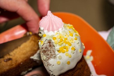 Erkek eller küçük paskalya pastası, sarı toz, kremayla süslenmiş, kanlı hamurlar, parçalar, iştah açıcı, mavi arka plan, tatil, açık kilise, dinsel