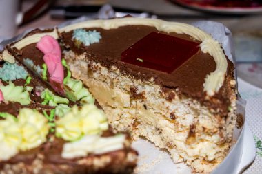 Kremalı dilimlenmiş çikolatalı pasta, ortada hafif, serpilmiş kenarlar, masada tatlı, süslemeli, siyah krema, tereyağı çiçekleri, hamur işleri, jöle, lezzetli yiyecekler, havadar kremalar, beyaz hamurlar, kakao, mutfak, yatay fotoğraf, yakın çekim, üst manzara