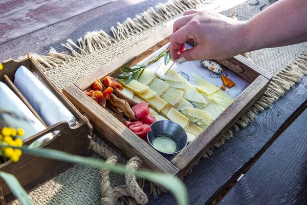 İnsanlar peyniri, kürdanlı yarağı, farklı türde ahşap tahtaları, çeşitli peynirleri, abur cuburları deniyorlar.