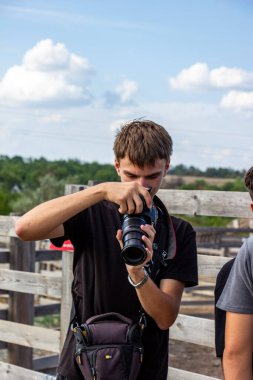 Kahverengi gözlü, kameralı genç bir çocuğun portresi, fotoğraf çekiyor, vizörüne bakıyor, esmer,