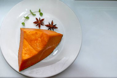 Beyaz tabakta bir parça balkabağı, balkabağı meyvesi, baharat, portakal sebzesi, nane filizi, mikro yeşil, yakın plan, zengin renk, iç posa, taze, sağlıklı yiyecek, olgun meyve, kesik, vegan yemeği, kahvaltı, üst manzara, makro, yatay fotoğraf