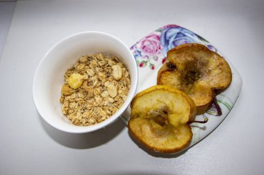 Bir tabakta pişmiş elma ve fındıklı kuru yulaf ezmesi, mısır topu, mısır gevreği karışımı, vitaminler, kahvaltı, akşam yemeği, fast food, tatlı, sağlıklı yemek, yakın çekim, yatay fotoğraf, açık arkaplan,