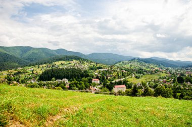 Dağlardaki köylerin yamaçlarındaki özel evler, yollar, çimenler, güneşli günler, Ukrayna Karpatları, dağlar, bahar-yaz dönemi, güneşli gün, yatay fotoğraf, çimenlerdeki patika, eşsiz manzara, turizm merkezi