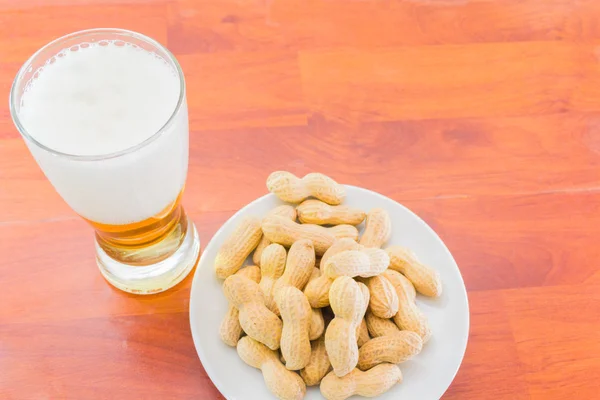 Vaso de cerveza y cacahuetes sin pelar —  Fotos de Stock