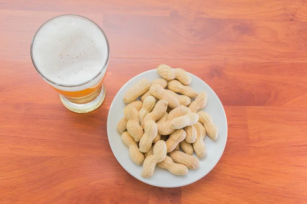 Bardak bira ve soyulmamış fıstık — Stok fotoğraf