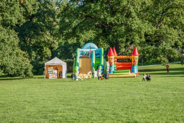 Renkli, şişme bir çocuk cazibesi ve güneşli bir günde parkta küçük bir seyyar pamuk şeker dükkanı. Neşeli sahne çocukluk, açık hava eğlencesi ve neşeli atmosferi yakalar. Boş zamanları ve aile eğlencelerini resmetmek için mükemmel.