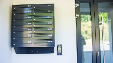Bir apartmanın girişinde kilitleri olan metal posta kutuları sistemi. Şehir konutları gündüz gözüyle. 