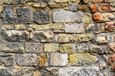 Eski tuğla işlerinden ve düzensiz şekilli taşlardan oluşan bir arka plan. Yatay renk fotoğrafı