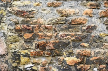 Eski, kömürleşmiş, harç dolu küçük bir alana sahip duvarda harap olmuş kırmızı tuğlaların rengarenk bir arka planı.