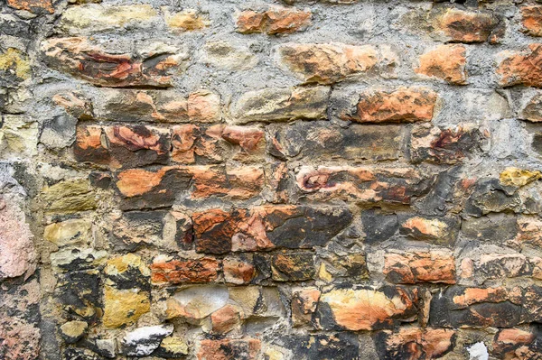 Eski, kömürleşmiş, harç dolu küçük bir alana sahip duvarda harap olmuş kırmızı tuğlaların rengarenk bir arka planı.