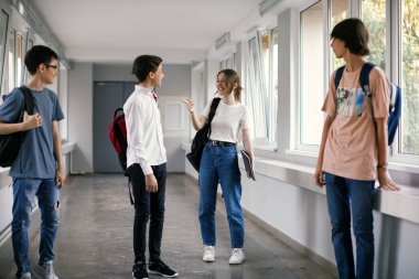 Sınıf arkadaşları tatilde okulun koridorunda yürüyorlar.